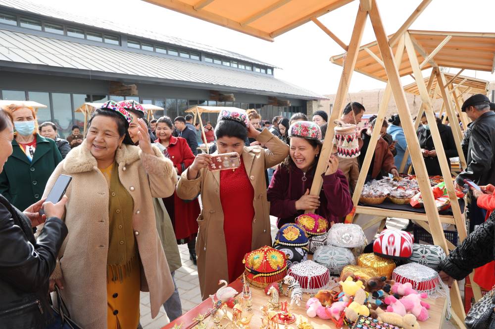 KUQA - Tourists buy special local products at a market in Kuqa City in northwest China's Xinjiang Uygur Autonomous Region, March 15, 2024. TO GO WITH 