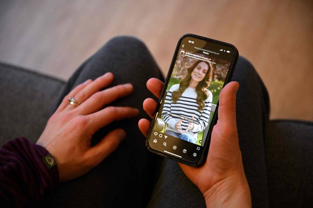 A woman in the village of Marsden, northern England, watches a recording of Britain's Catherine, Princess of Wales, announcing her cancer diagnosis, on March 22, 2024. Britain's Catherine, Princess of Wales, announced that she has cancer and was in the early stages of chemotherapy, asking for "time, space and privacy" as she finishes her treatment. (Photo by Oli SCARFF / AFP)
