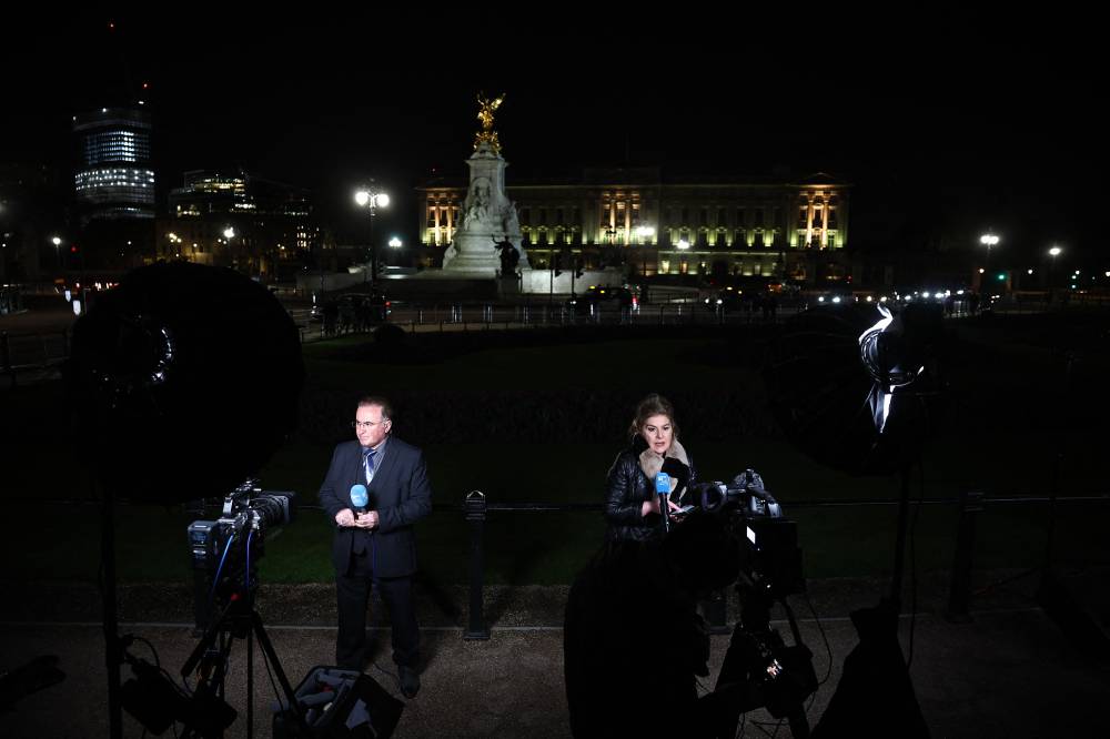 Broadcast journalists report from outside Buckingham Palace in London on March 22, 2024. Britain's Catherine, Princess of Wales, announced that she has cancer and was in the early stages of chemotherapy, asking for 