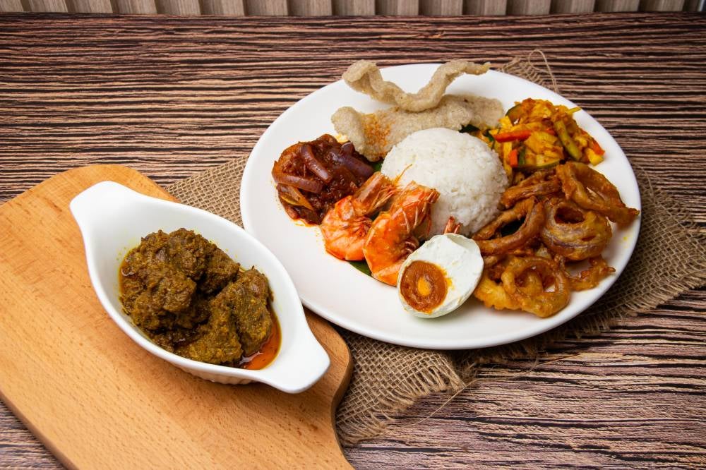 Rice Set Menu with Beef Rendang as gravy of choice with a side of fried onion, salted egg, fried prawn, acar and fish crackers.