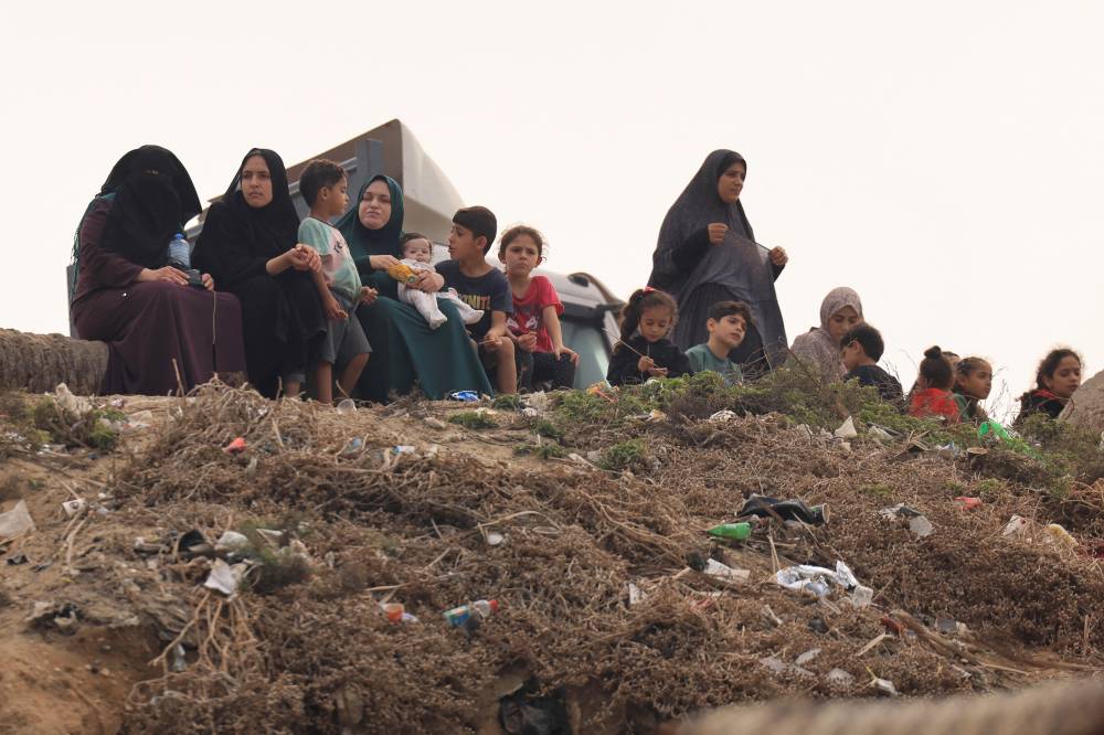 Palestinian women and children sit along the sea front in Deir el-Balah in the southern Gaza Strip on Oct 29, 2023 amid ongoing Israeli attacks. - (Photo by MAHMUD HAMS / AFP)