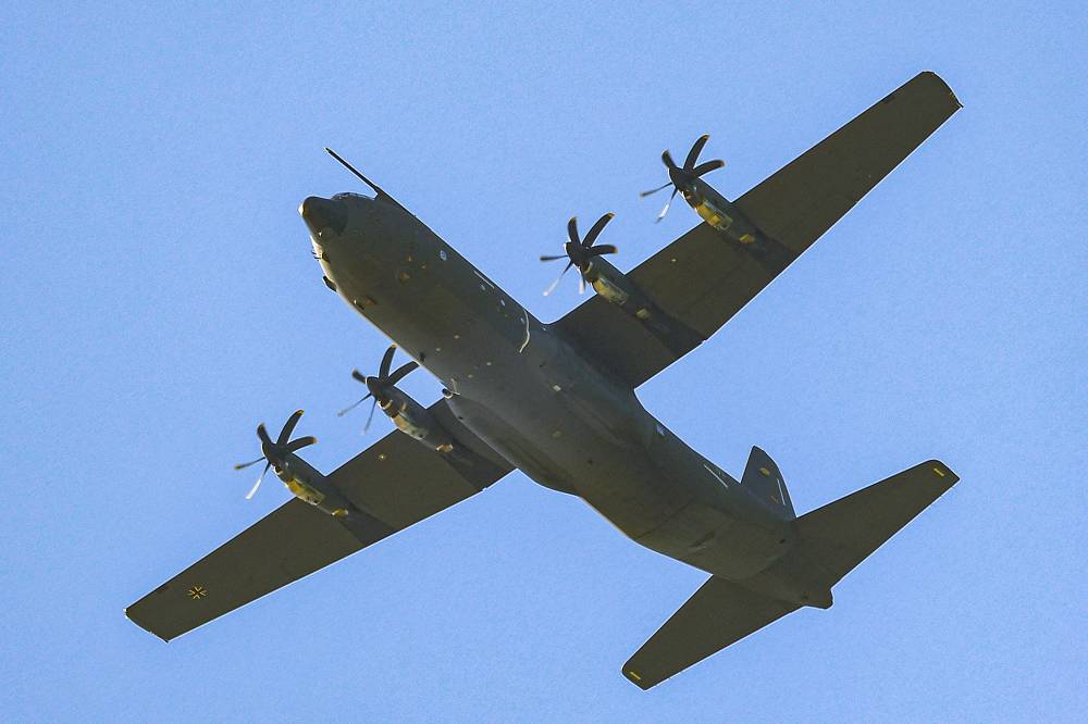 A German Air Force C-130 Hercules turboprop military transport aircraft flies over during a humanitarian aid drop on the Gaza Strip, west of Gaza City, on March 25, 2024 amid ongoing Israeli attacks on Gaza. - Photo by AFP