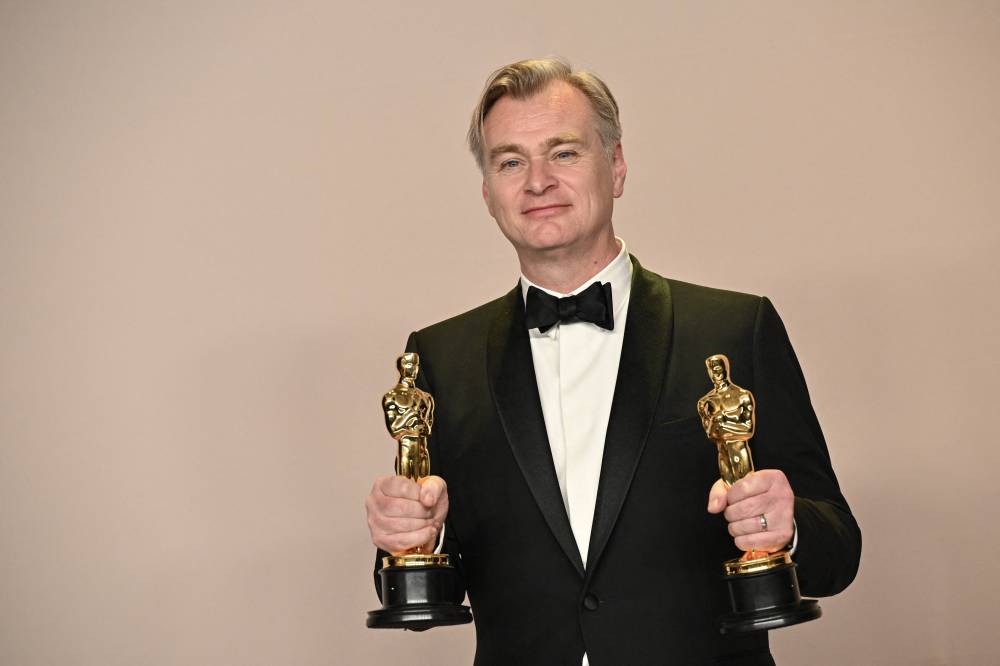 British director Christopher Nolan poses in the press room with the Oscars for Best Director and Best Picture for "Oppenheimer" during the 96th Annual Academy Awards at the Dolby Theatre in Hollywood, California on March 10, 2024. - (Photo by ROBYN BECK / AFP)
