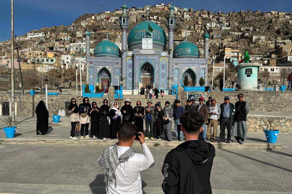 In this picture taken on March 25, 2024 Thai tourists pose for a group picture during their visit to the Kart-e-Sakhi Shrine in Kabul. His soldier son toured Afghanistan with insurgents in his crosshairs, but American traveller Oscar Wells has a different objective -- sight-seeing promoted by the Taliban's fledgling tourism sector. "It is a unique place, it touches my heart," the 65-year-old Indiana farmer told AFP, praising the "unique" country and "its magnificent mountains" with "people living in the old way". (Photo by Wakil Kohsar / AFP) / To go with "AFGHANISTAN-TOURISM, REPORTAGE' by Pascale TROUILLAUD