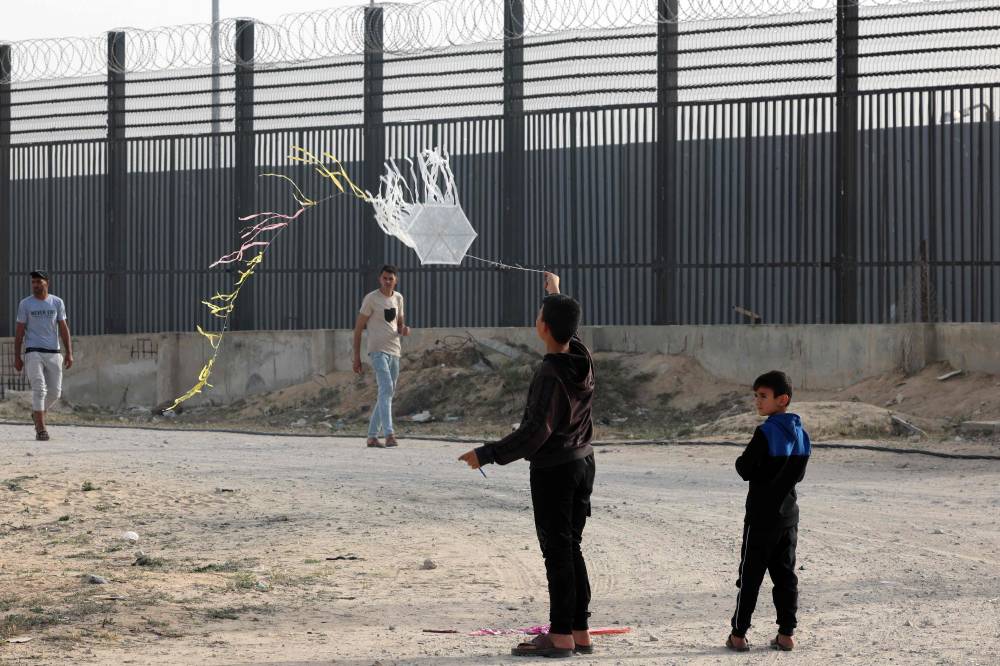 A displaced Palestinian child flies a kite near the border with Egypt in Rafah in the southern Gaza Strip on March 28, 2024, amid the ongoing conflict between Israel and Hamas. (Photo by Said Khatib/AFP