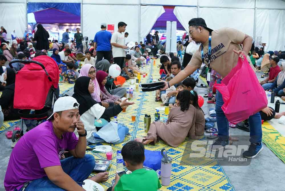 Staff members distribute food to the visitors of the Iftar Ala Madinah@Karangkraf. Photo Sinar Harian - MOHD HALIM ABD WAHID 