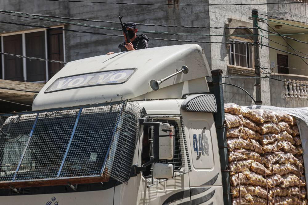 Member of "People's Protection Committees" guards a humanitarian aid truck in Rafah in the southern Gaza Strip on April 3, 2024. - (Photo by SAID KHATIB / AFP)