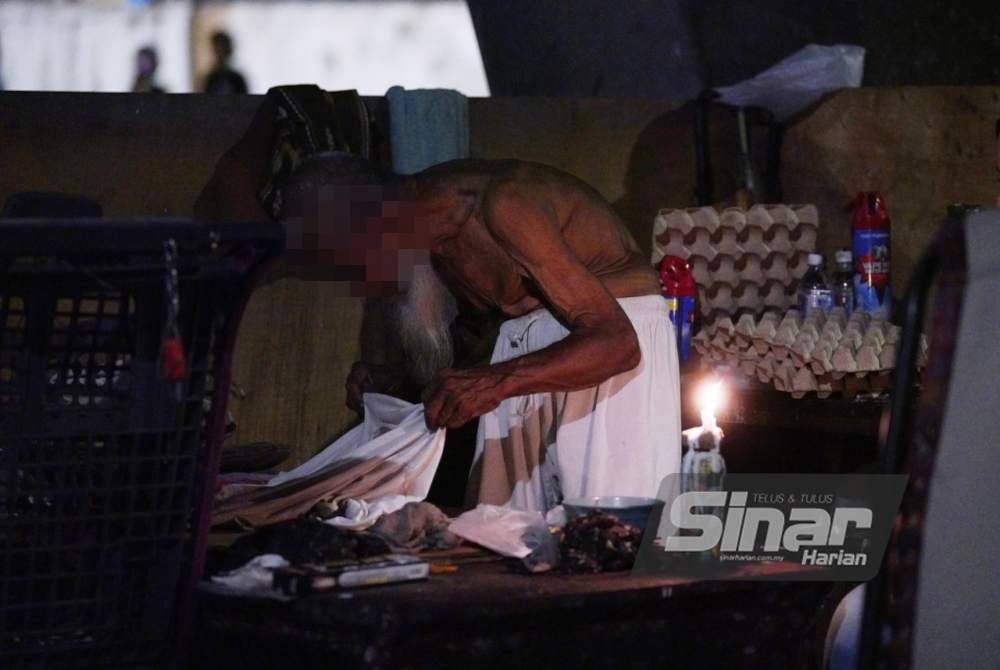 Mat Isa tidies up his living space under the bridge on Jalan Yew, Kuala Lumpur. - Photo by MOHD HALIM ABDUL WAHID 