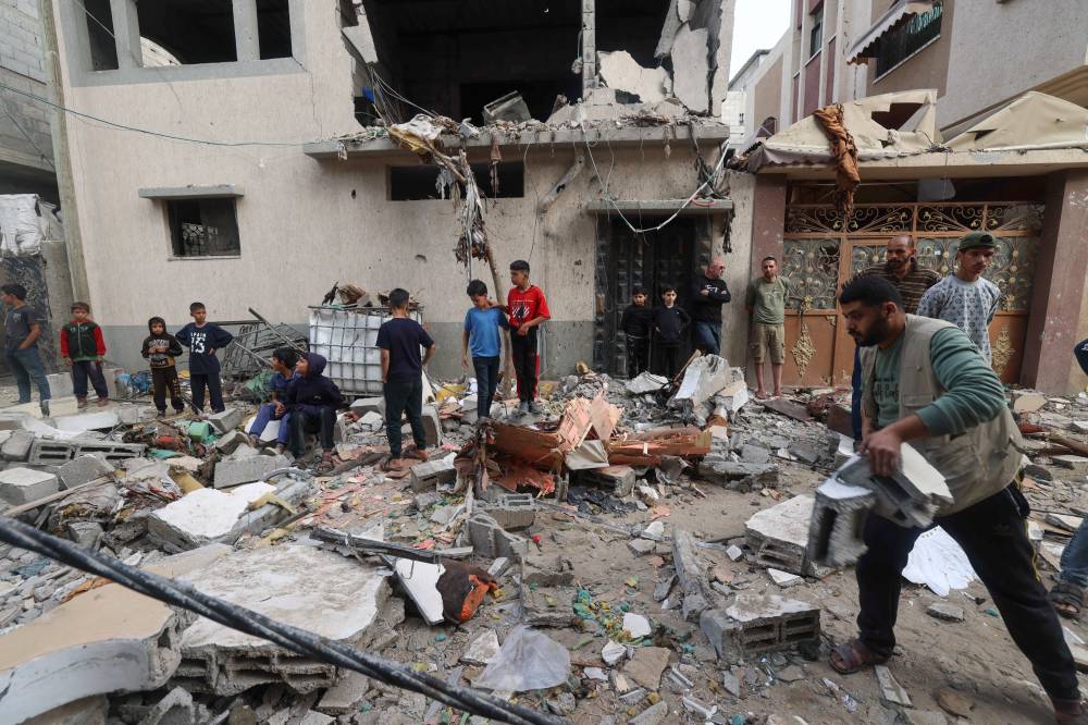 Palestinians clear building rubble following overnight Israeli bombardment in Rafah in the southern Gaza Strip on April 4, 2024. - (Photo by MOHAMMED ABED / AFP)