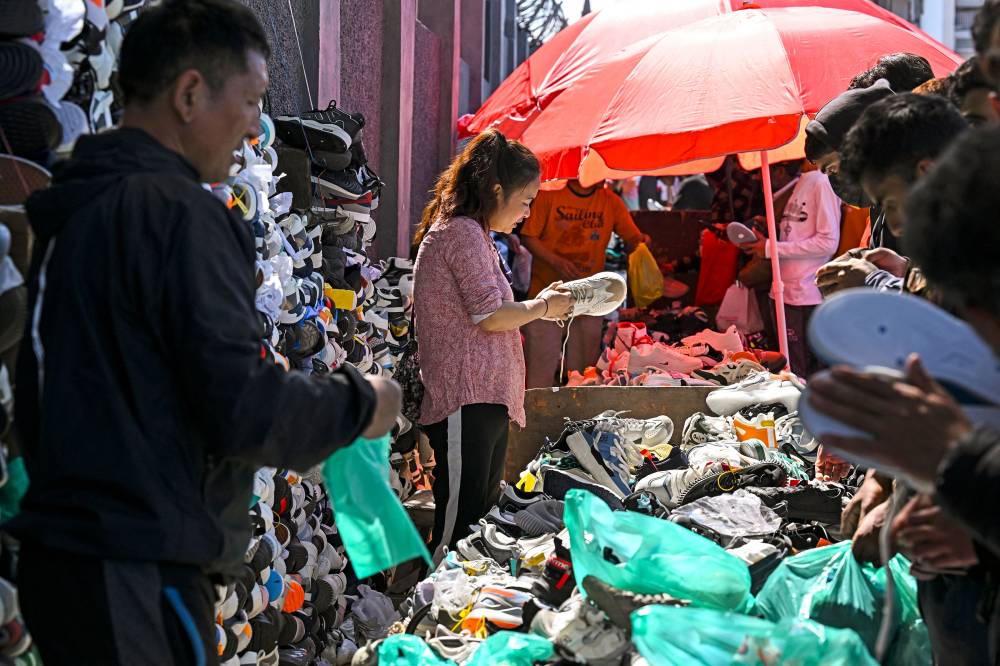 Roadside vendors sell shoes at a market in Srinagar on April 9, 2024. - Illustrative photo by AFP