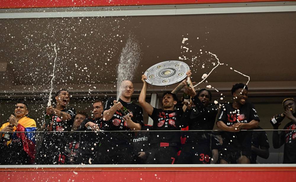 Bayer Leverkusen's players celebrate with a mock-up of the Bundesliga trophy after the German first division Bundesliga football match Bayer 04 Leverkusen v Werder Bremen in Leverkusen, western Germany, on April 14, 2024. - Photo by AFP
