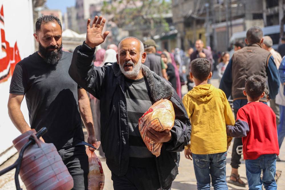 A Palestinian man reacts after buying subsidised bread outside a bakery in Gaza City on April 14, 2024. (Photo by AFP)