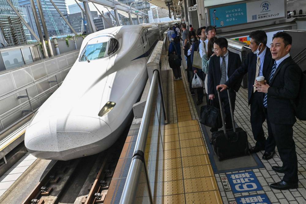 Passengers wait on the platform as a Kodama bullet train, or "shinkansen" service to the city of Nagoya arrives to pick up passengers at Tokyo station in central Tokyo on April 17, 2024. A passenger on the evening of April 16 alerted security to a 40-centimetre (nearly 16-inch) snake lurking on a train between Nagoya and Tokyo, resulting in a 17-minute hold-up. (Photo by AFP)
