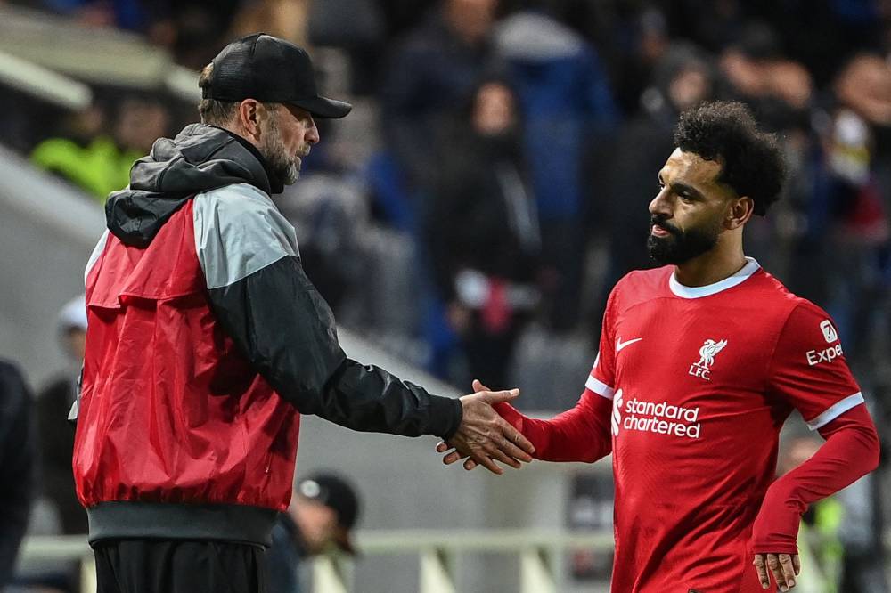 Liverpool's German head coach Jurgen Kloppduring (L) acknowledges Liverpool's Egyptian forward #11 Mohamed Salah as he leaves the pitch during the UEFA Europa League quarter-final second leg football match between Atalanta BC and Liverpool FC at the Atleti Azzurri d'Italia Stadium in Bergamo, on April 18, 2024. (Photo by AFP)