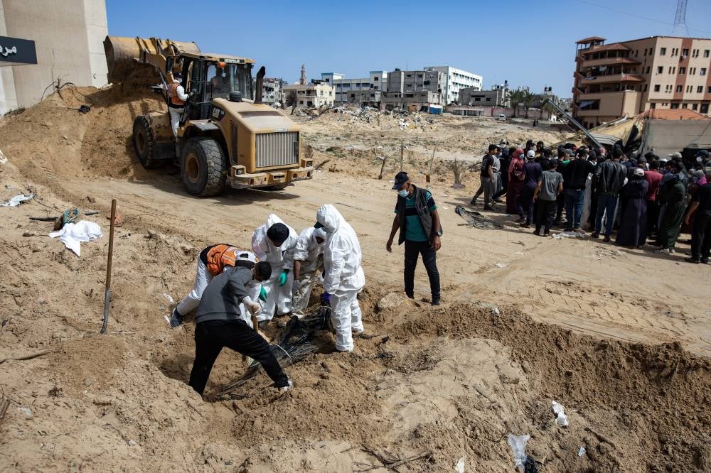 The Palestinian Civil Defense recovers 50 bodies from a mass grave inside Nasser Hospital in Khan Yunis. Photo by EPA.