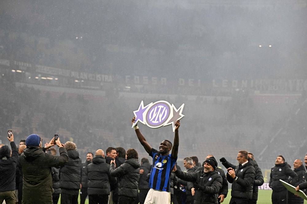 Inter Milan's French forward #09 Marcus Thuram celebrates winning the 2024 Scudetto championship title on April 22, 2024, following the Italian Serie A football match between AC Milan and Inter Milan at the San Siro Stadium in Milan. (Photo by AFP)