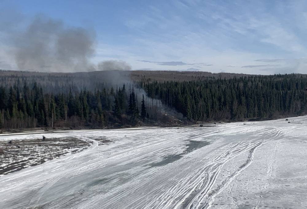This handout photo released by Alaska State Troopers on April 23, 2024 shows smoke rising from the site of a plane crash outside Fairbanks, Alaska, after a Douglas DC-4 crashed into the Tanana River after taking off from Fairbanks International Airport. - Photo by AFP
