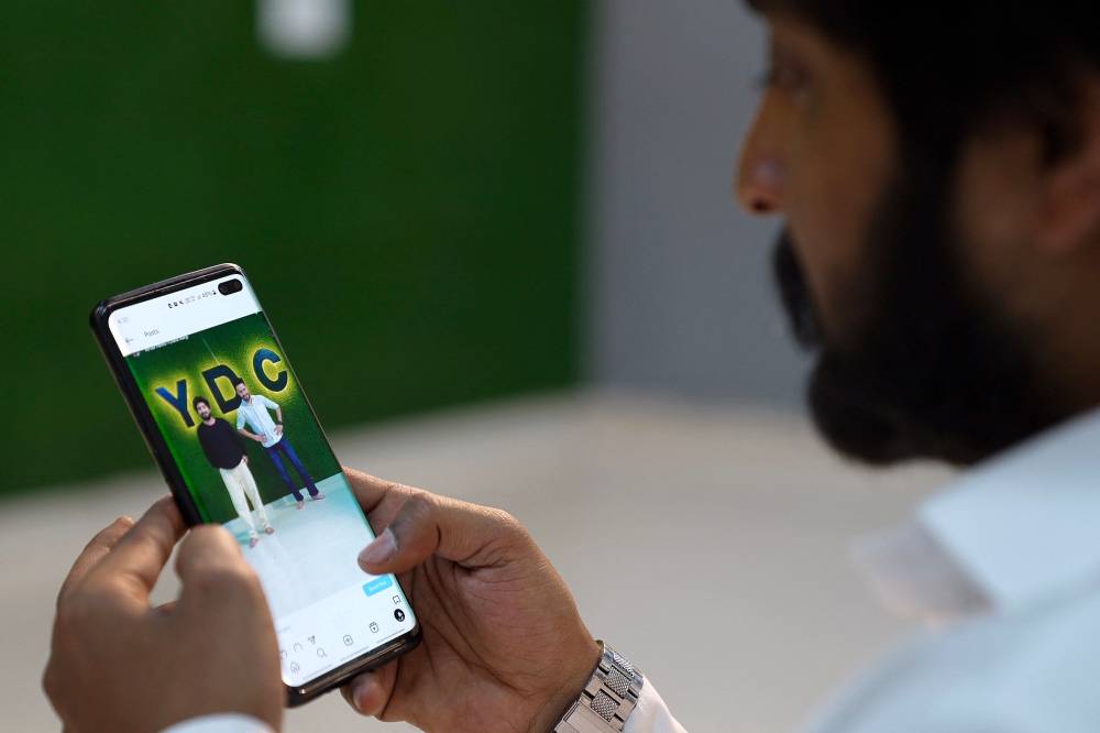 This screengrab taken from AFPTV video footage on April 27, 2024 shows choreographer Sahil Kumar watching his dance video uploaded on social media platform Instagram, at a studio in Rohtak. - Photo by AFP