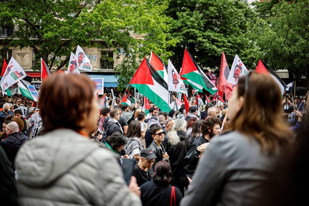 People hold Palestinian flags during the yearly protest marking International Labour Day, also known as Workers Day or May Day, in Paris on May 1, 2024. (Photo by OLYMPIA DE MAISMONT / AFP)