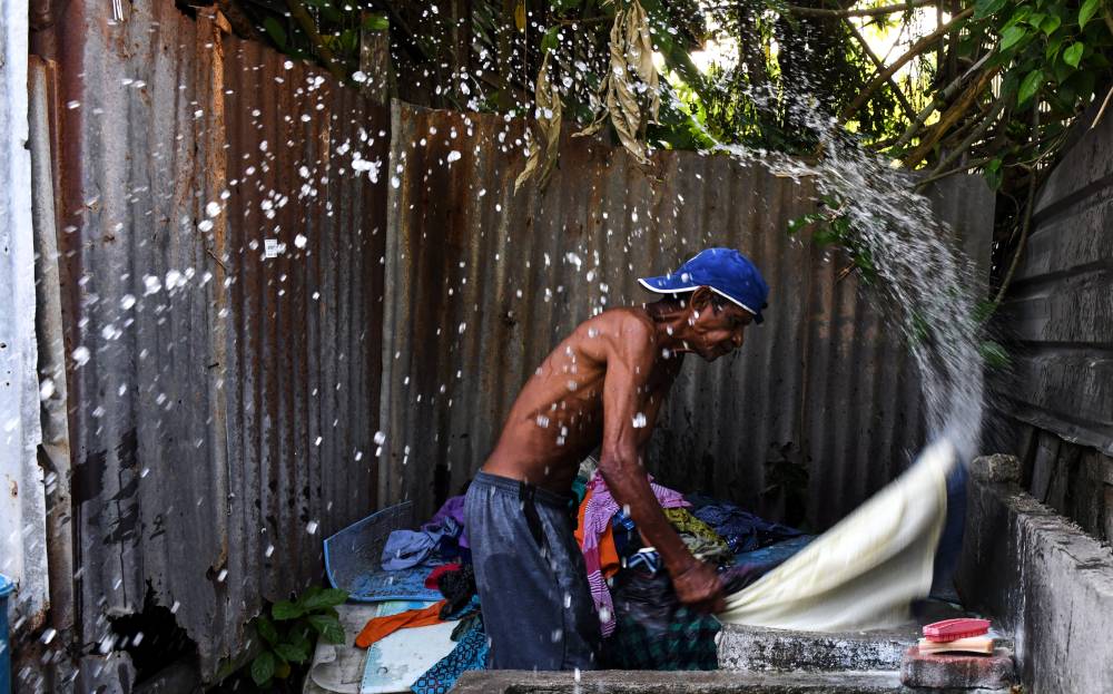A worker washing the laundry. Photo by Bernama