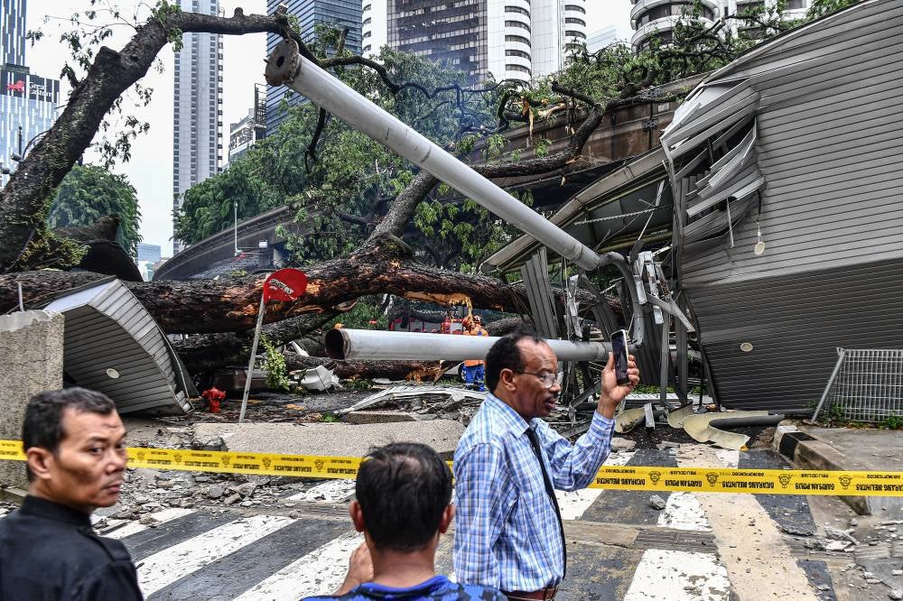 Incident of a fallen tree on the tracks near the Raja Chulan Monorail station in Kuala Lumpur during a storm this afternoon. - Photo by Bernama