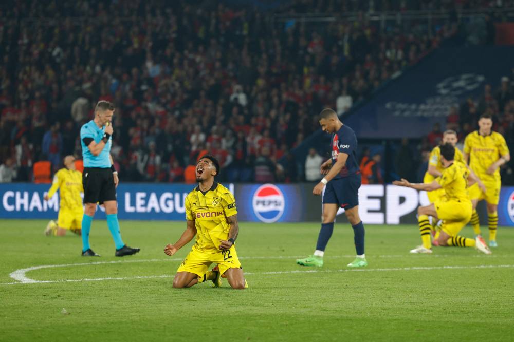 Dortmund's Dutch defender #22 Ian Maatsen (CL) celebrates Dortmund's victory in front of Paris Saint-Germain's French forward #07 Kylian Mbappe (CR) at the end of their UEFA Champions League semi-final second leg football match against Paris Saint-Germain (PSG) at the Parc des Princes stadium in Paris on May 7, 2024. (Photo by AFP)
