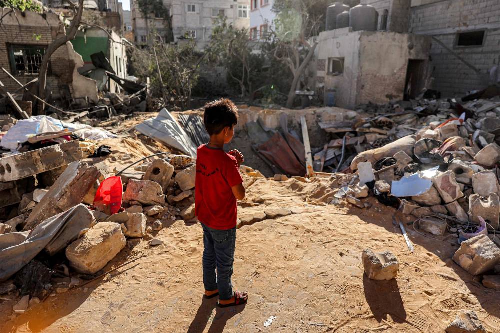 A boy stands before an impact crater at the site of a building that was hit by Israeli bombardment in Rafah in the southern Gaza Strip on May 8, 2024. (Photo by AFP)