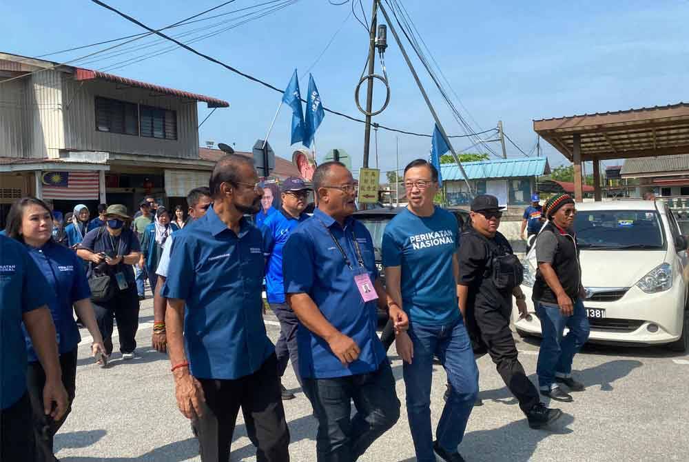 Dominic (right) campaigning alongside PN candidate, Khairul Azhari, in and around Kampung Baharu Kerling on Friday.