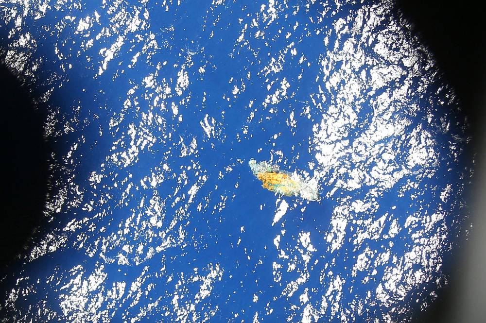 A piece of unknown debris floats just under the water as seen from a Royal New Zealand P3 Orion while it searches for the missing Malaysia Airlines flight MH370, over the Indian Ocean on March 31, 2014. - FILE PIX by AFP