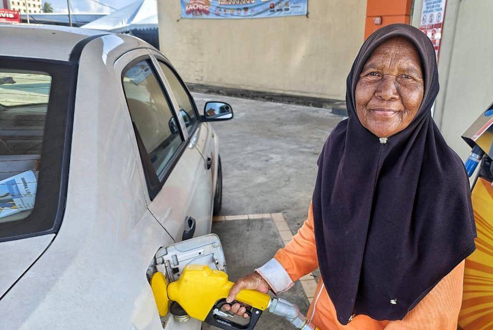 Zainab filling petrol into a vehicle's tank at a petrol station in Kuantan.