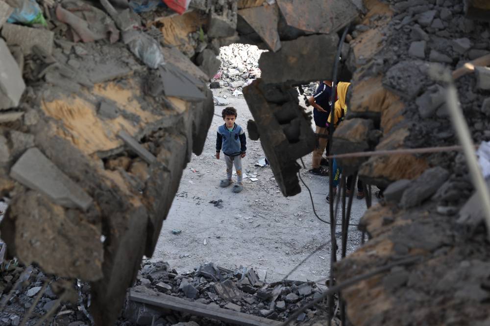 A Palestinian child stands in front of a building destroyed by Israeli bombing in Rafah in the southern Gaza Strip on May 3, 2024. - Photo by AFP