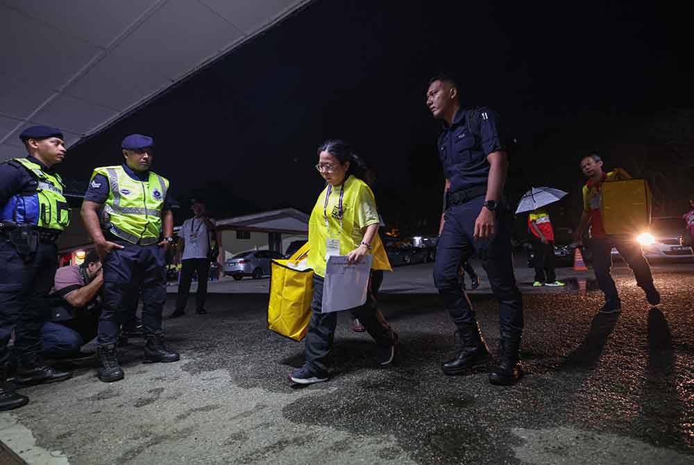 Election Commission officers carrying ballot boxes. Photo by Bernama