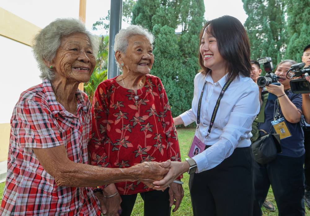 Pakatan Harapan candidate Pang Sock Tao engages in friendly interaction with elderly voters Yuen Yoon, 89, (left) and his friend Chin Choon Kew, 89, (center) during the Kuala Kubu Baharu (KKB) State Assembly by-election at the polling center of Khing Ming Chinese National Type School (SJKC), today. (BERNAMA) 