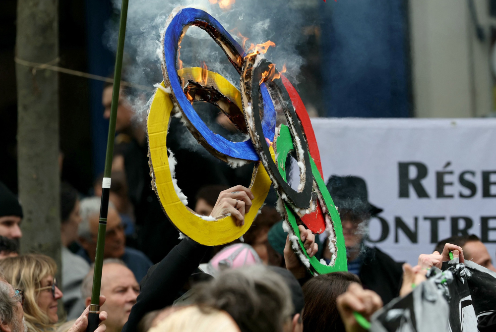 People burn Olympic rings made with cardboard during the yearly protest marking International Labour Day, also known as Workers Day or May Day, in Paris on May 1, 2024. - File photo by AFP
