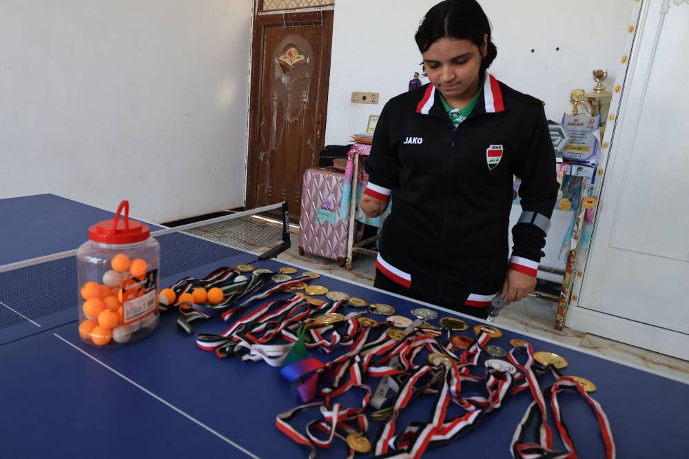 Iraqi paralympics table tennis athlete Najla Imad, displays her medals at her house in Baqubah, on February 26, 2024. - Photo by AFP