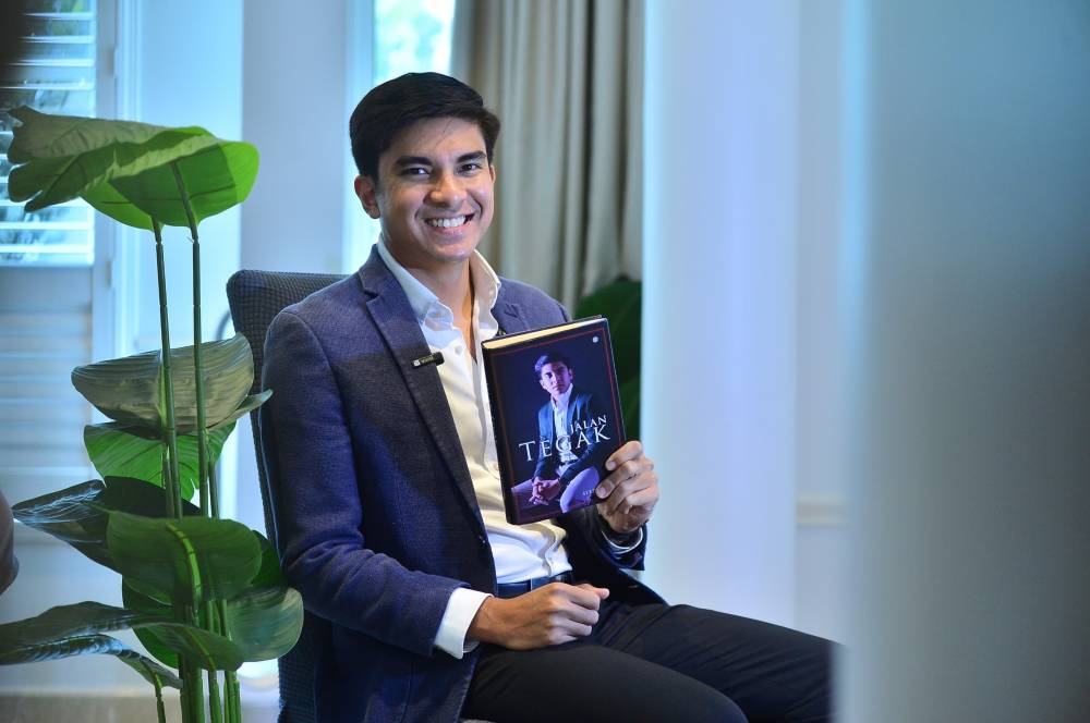 Muar MP Syed Saddiq Syed Abdul Rahman holding his book entitled "Jalan Tegak" which will be launched on June 2. - Photo by ASRIL ASWANDI SHUKOR