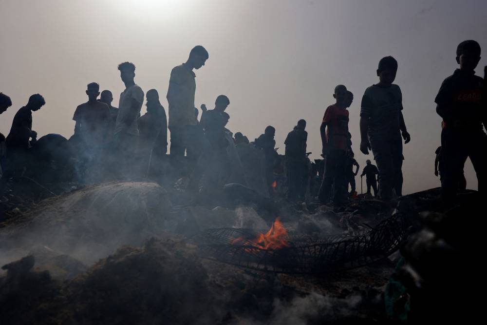 Palestinians gather at the site of an Israeli strike on a camp for internally displaced people in Rafah. Photo by Eyad Baba/AFP.