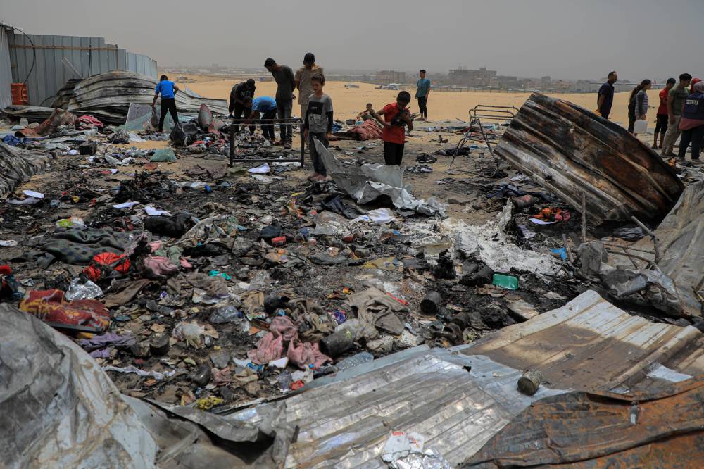 Palestinians are seen at the site of an Israeli airstrike on tents for displaced people near the southern Gaza Strip. Photo by Rizek Abdeljawad/Xinhua