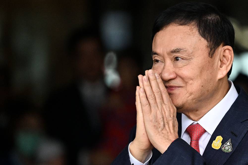 Former Thai Prime Minister Thaksin Shinawatra greets his supporters after landing at Bangkok's Don Mueang airport on August 22, 2023. - File photo by AFP 