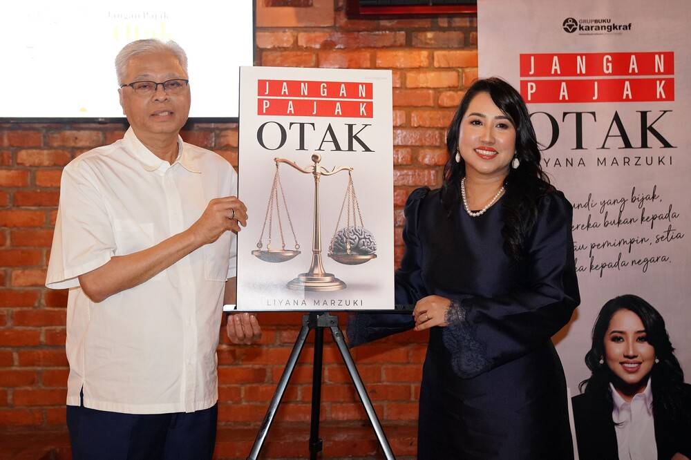 Former prime minister Datuk Seri Ismail Sabri Yaakob (left) with the author Liyana Marzuki launched the book "Jangan Pajak Otak" at an event held on Friday.