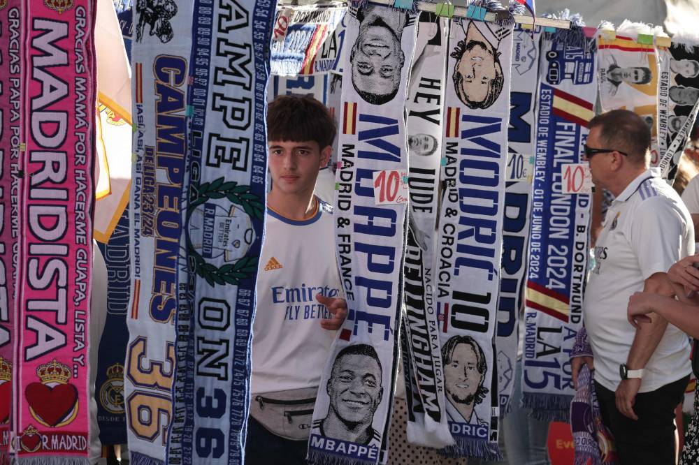 Football scarves of French footballer Kylian Mbappe and Croatian player Luka Modric are displayed at a street vendor stand outside the Santiago Bernabeu stadium in Madrid prior to the celebration in London of the UEFA Champions League final football match between Borussia Dortmund and Real Madrid, on June 1, 2024. (Photo by AFP)