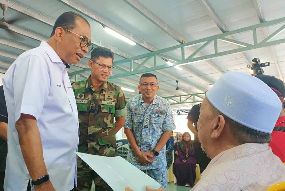 Khaled (left) comforts the family of Nor Rahiza Anuar, represented by her father Anuar Hassan and husband Mohd Azinor Azizan.

