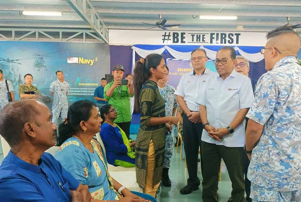 The widow of the late T Sivasutan, S Harshini receive the LTAT contribution, presented by Khaled (second from right).
