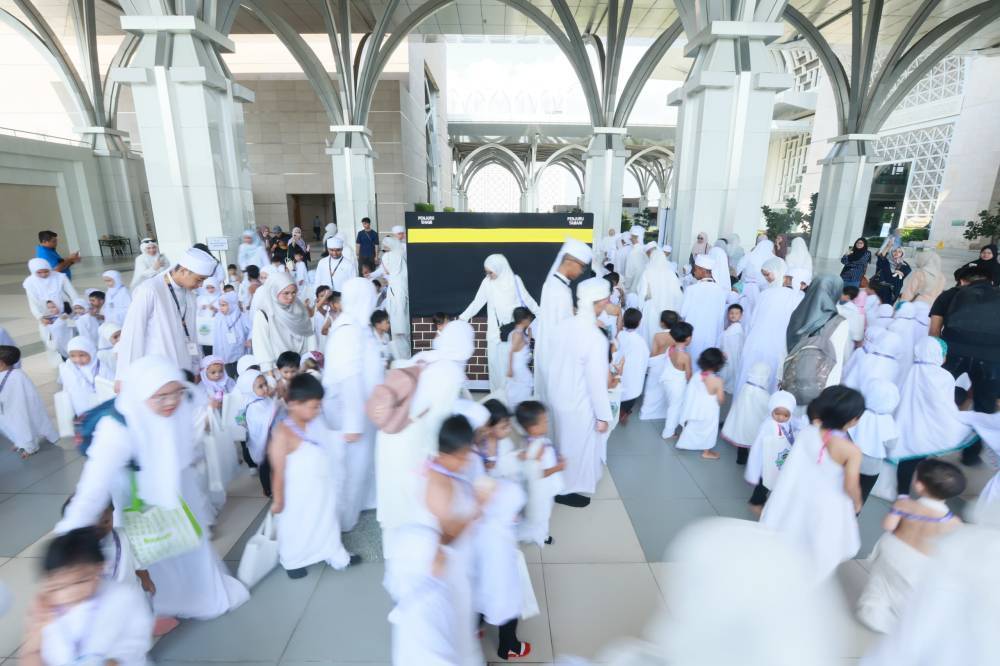 Children followed by teachers and mutawwif guides perform circular movement around the Kaabah as a part of the tawaf ritual during the "Kembara Haji 2024" haj simulation programme organised by Koolkidz Academy at the Tuanku Mizan Zainal Abidin mosque in Putrajaya on June 12, 2024.