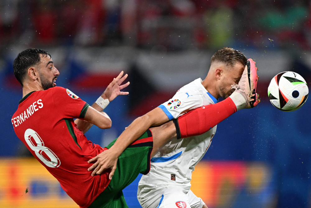 Portugal's midfielder #08 Bruno Fernandes (L) fights for the ball with Czech Republic's midfielder #07 Antonin Barak during the UEFA Euro 2024 Group F football match between Portugal and the Czech Republic at the Leipzig Stadium in Leipzig on June 18, 2024. (Photo by AFP)