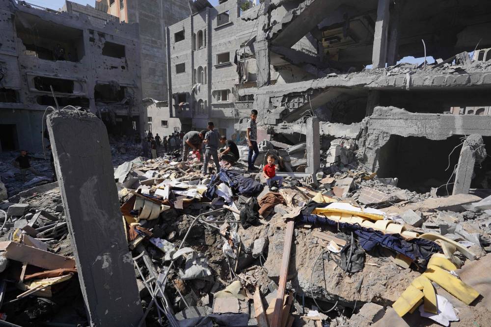 Palestinians search the rubble of the Harb family home which was hit in overnight Israeli strikes in al-Bureij refugee camp in the central Gaza Strip. Photo by Bashar Taleb/AFP