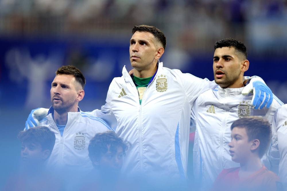 Argentina's forward #10 Lionel Messi (L), Argentina's goalkeeper #23 Emiliano Martinez (C) and Argentina's defender #13 Cristian Romero line up for the national anthem ahead of the Conmebol 2024 Copa America tournament group A football match between Argentina and Canada at Mercedes Benz Stadium in Atlanta, Georgia, on June 20, 2024. (Photo by AFP)
