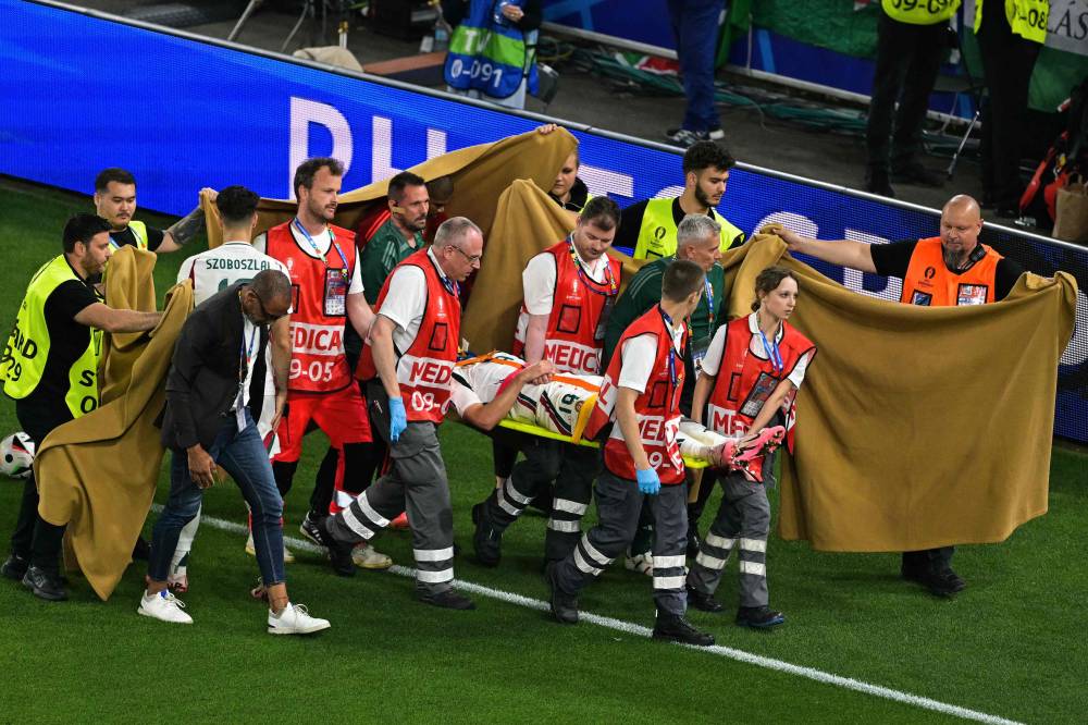 Hungary's forward #19 Barnabas Varga (C) is evacuated on a stretcher after getting injured during the UEFA Euro 2024 Group A football match between Scotland and Hungary at the Stuttgart Arena in Stuttgart on June 23, 2024. (Photo by AFP)
