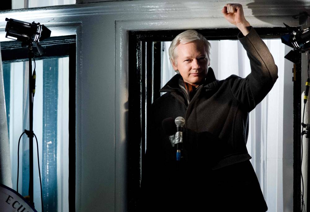 Wikileaks founder Julian Assange gestures as he addresses members of the media and supporters from the window of the Ecuadorian embassy in Knightsbridge, west London on December 20, 2012. - File photo by AFP