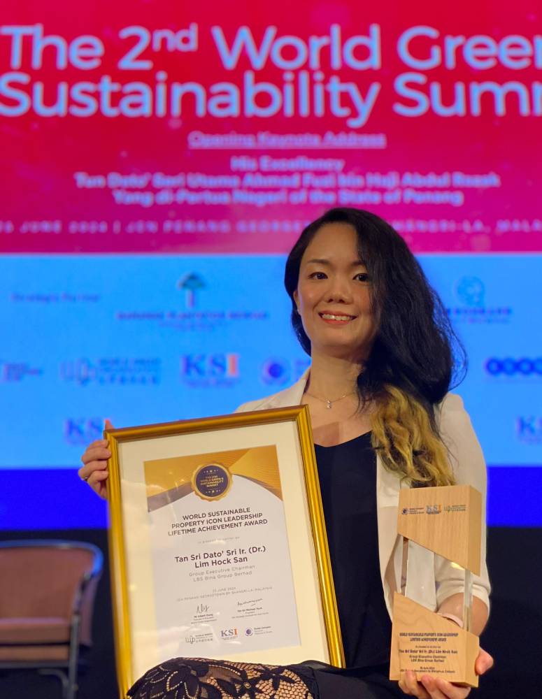 LBS Group Sustainability, Head, Shany Lim, showing the trophy and certificate conferred to Tan Sri Ir (Dr.) Lim Hock San during the 2024 World Green & Sustainability Summit held at JEN Penang Georgetown by Shangri-La, Malaysia.